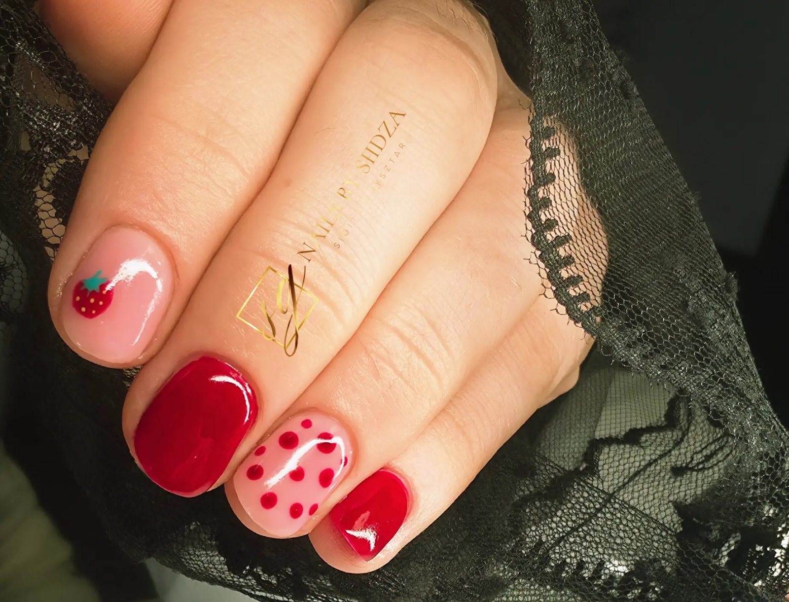 Red and nude nails with polka dot nail art on black lace