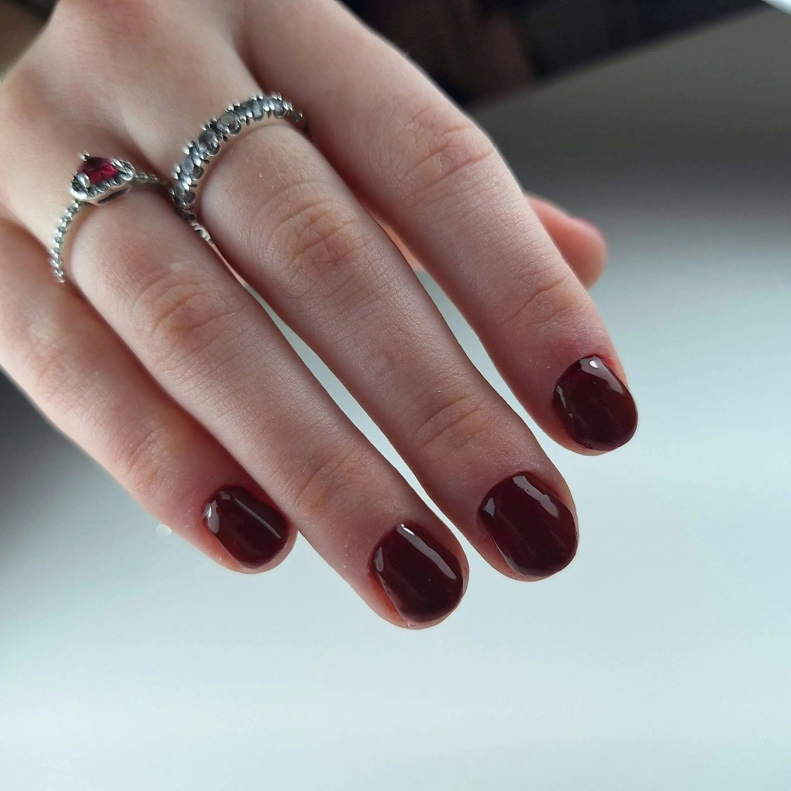 Deep burgundy gel nails with silver rings